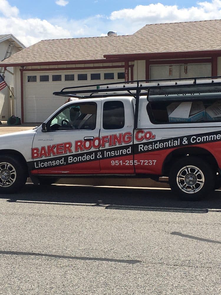 Baker Roofing's wrapped work truck — red lettering, black band, ladder rack — parked at a job